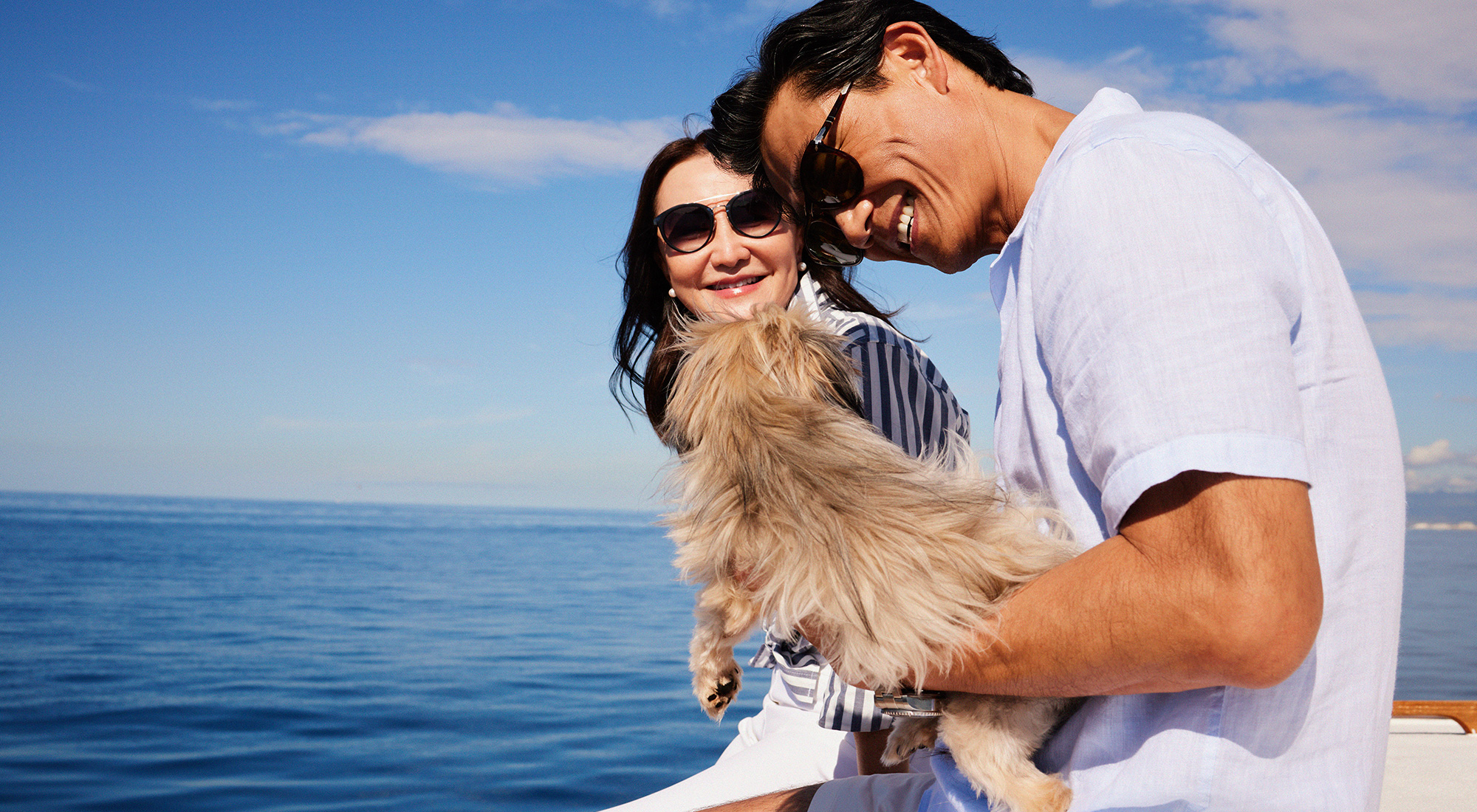 Couple sailing with small dog