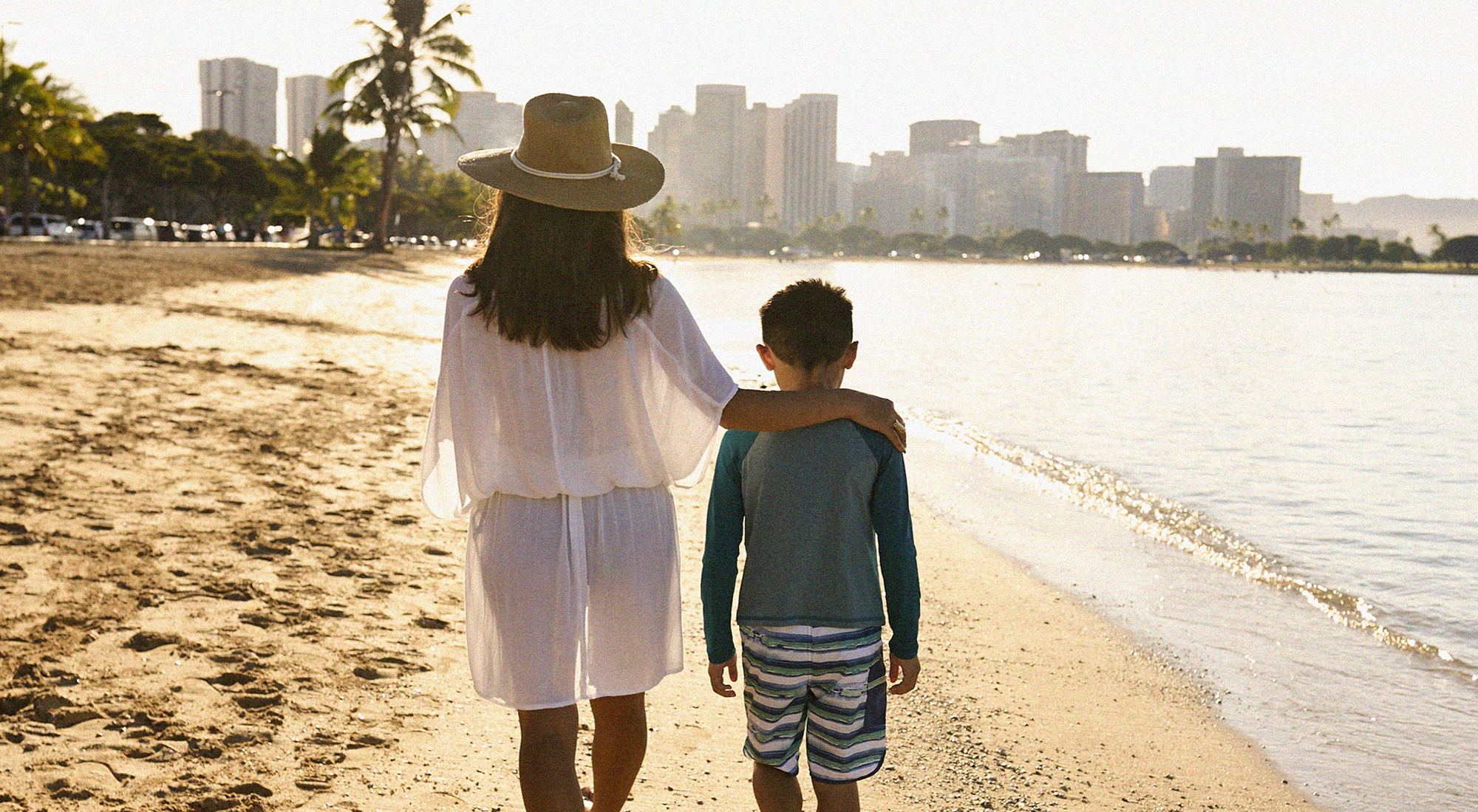 mother and child walking along beach